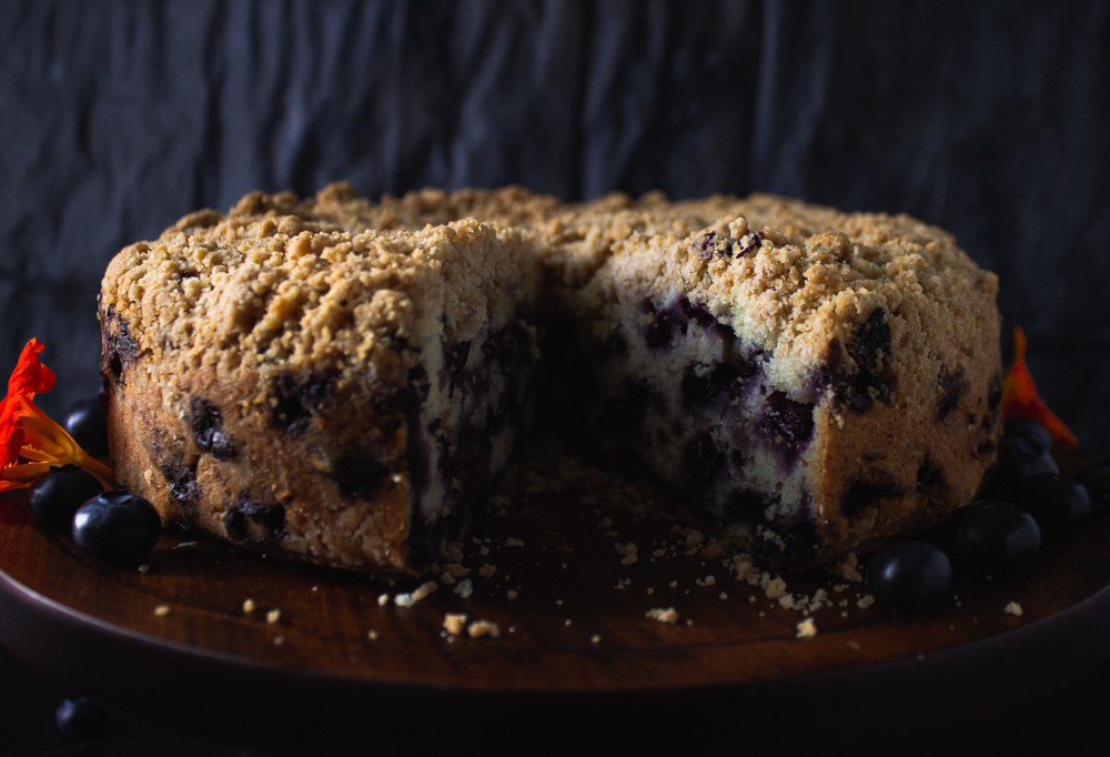 Side view of cut blueberry buckle on stand