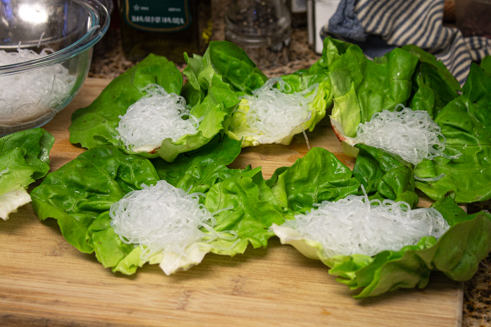 Lettuce on cutting board filled with bean thread noodles