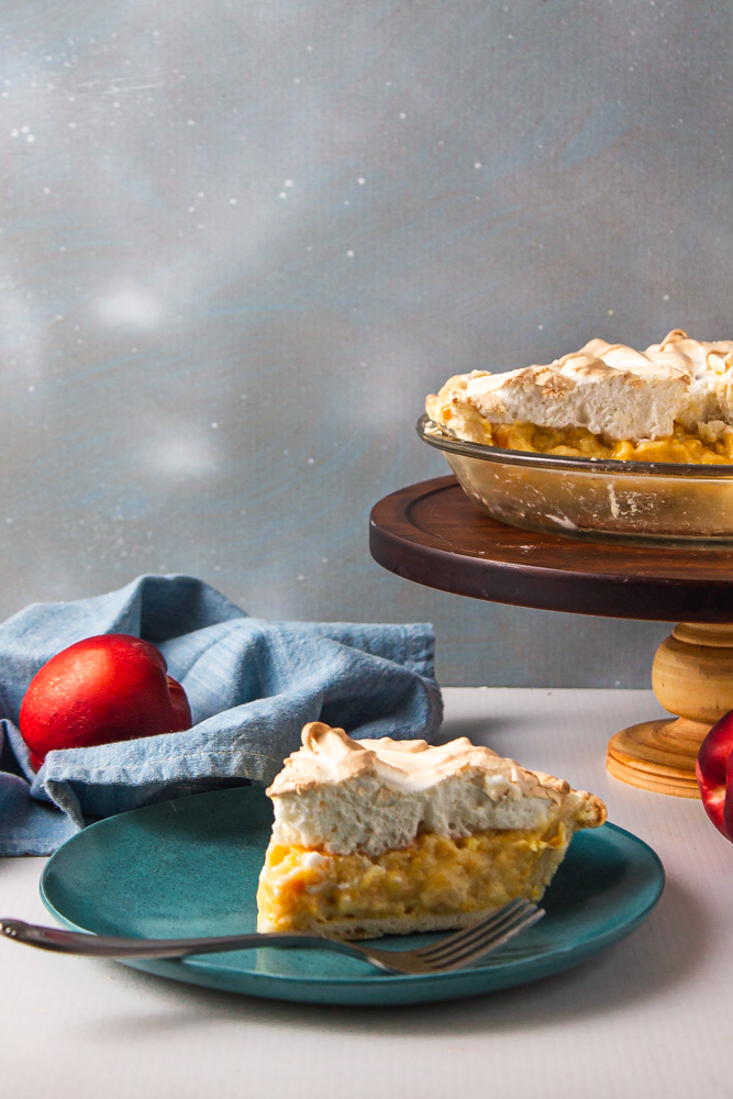 Slice of stone fruit pie with remainder in pan on stand
