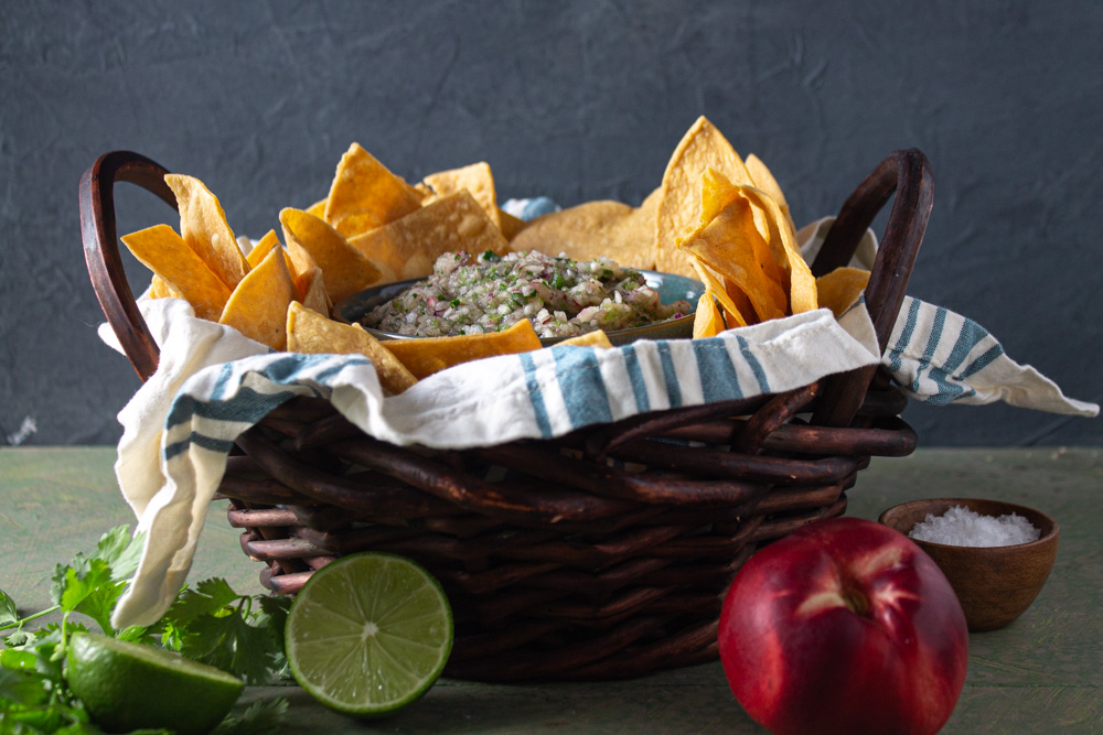 Side view white nectarine salsa with chips in basket