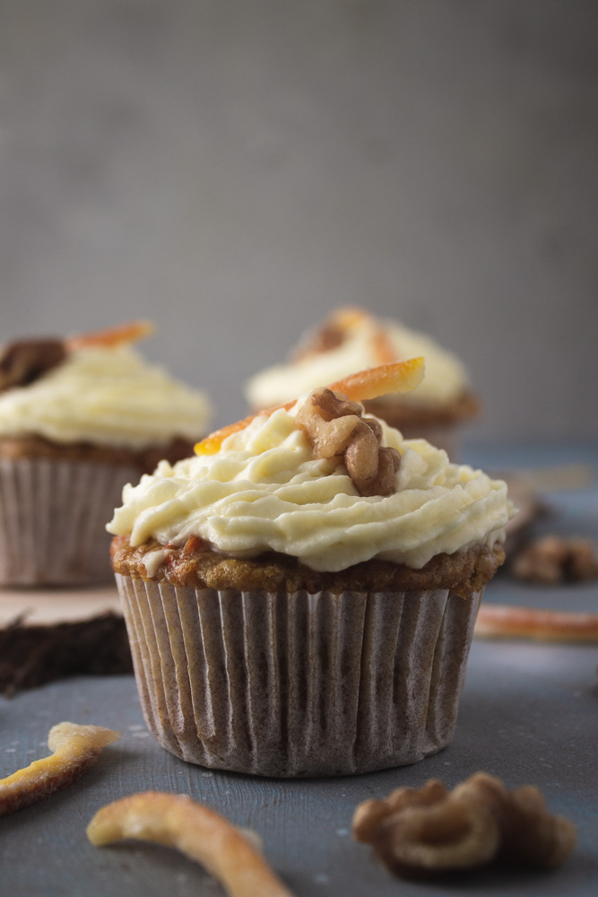 Side view of carrot cupcake with 2 in background