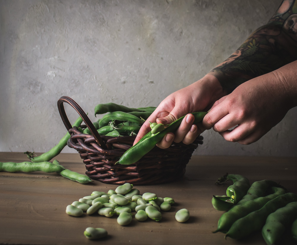 Shelling favas from a basket