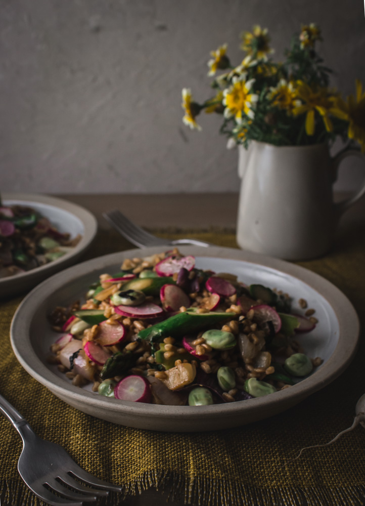Side angle of 2 plates of farro salad and flowers