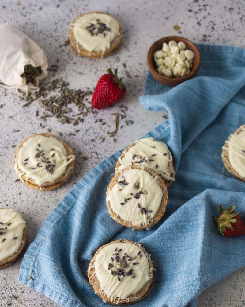 75 degree angle shot of strawberry lavendeer cookies on a blue cloth