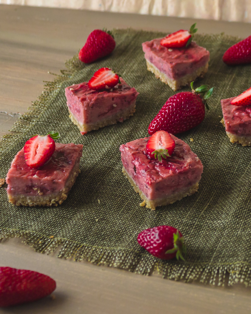 Angled picture of strawberry bars on green placemat