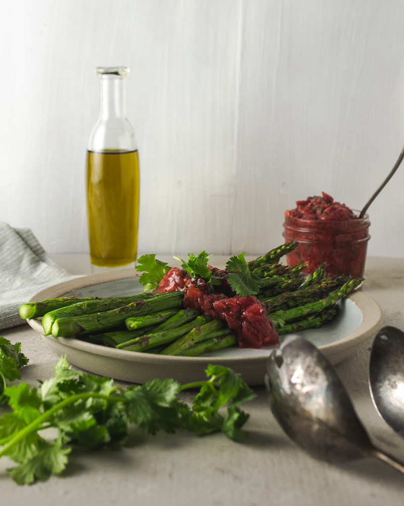 Asparagus and chutney with olive oil on a white plate