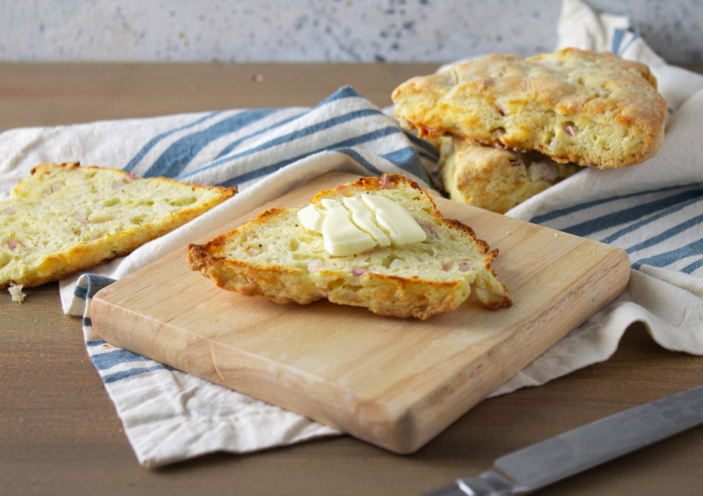 Butter on a cut scone resting on a wood board