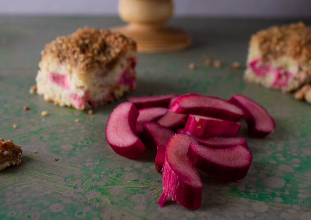 Rhubarb slices and rhubarb cream cake on green background