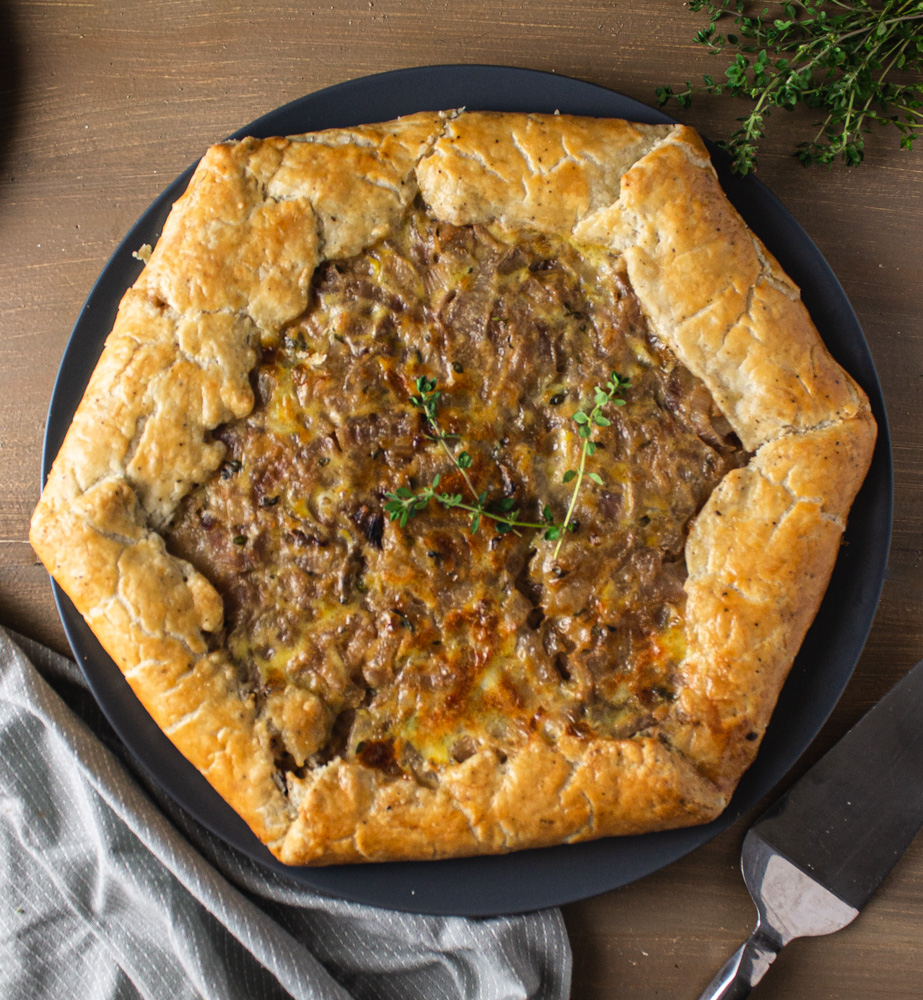 Overhead view of onion potato tart on wood background