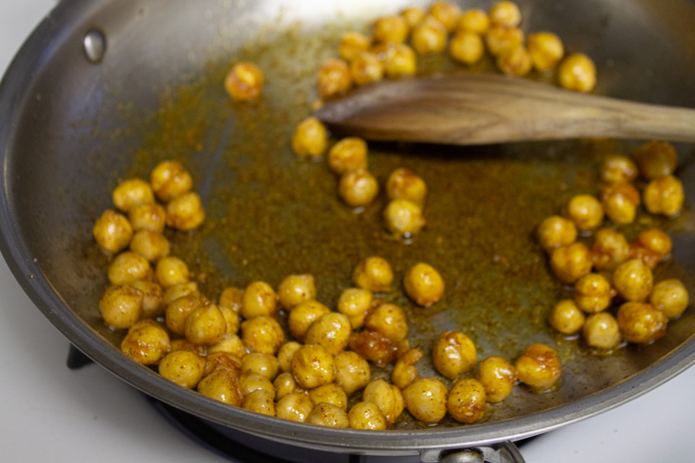Chickpeas crisping in pan with spices
