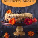 Side view of blue berry buckle on a cake stand with nasturtiums