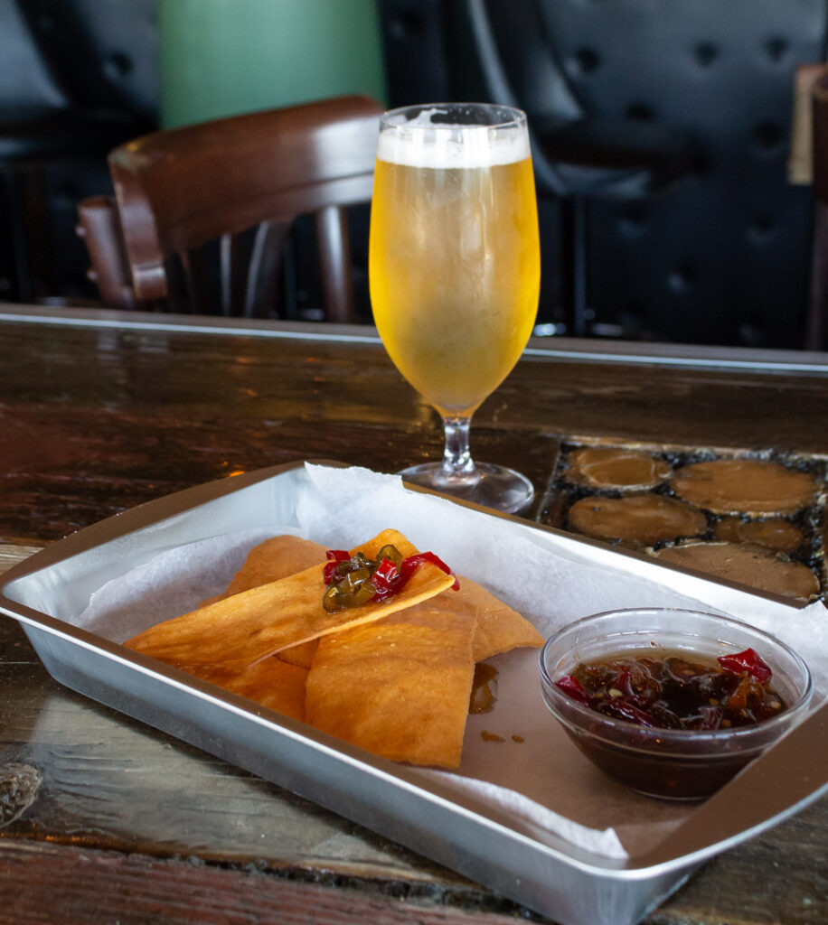 Olive oil crackers and pepper jelly with a beer