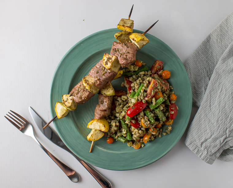 Plate with lime coriander tuna skewers and sage pesto farro salad