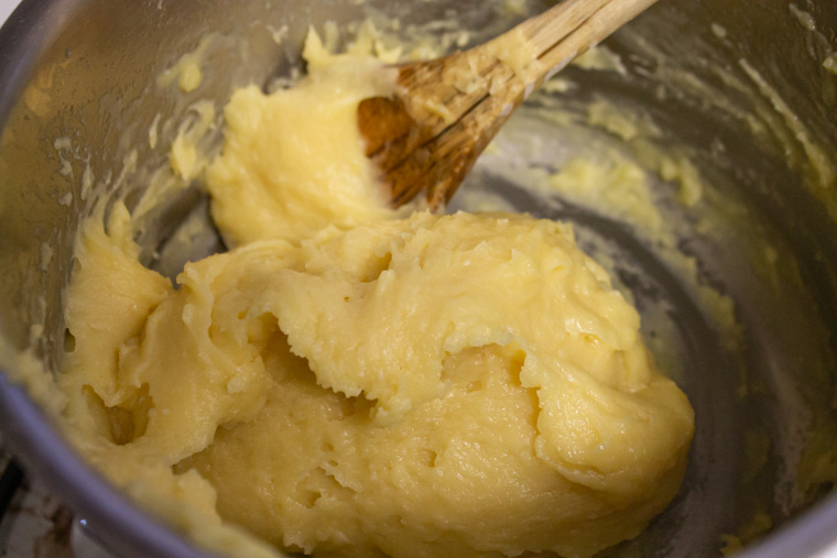 Choux paste with eggs being added