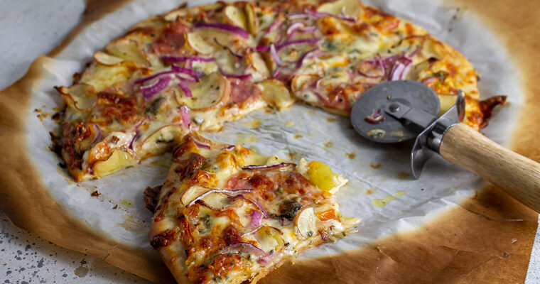 Pizza with potato, onion, and salami on a thin and chewy pizza crust