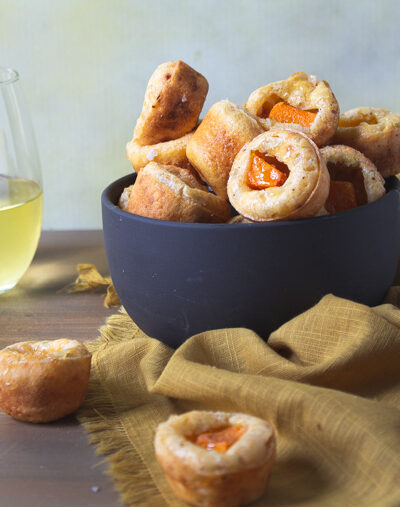 Glass of white wine paired with bowl of tapioca cheesee bread with butternut