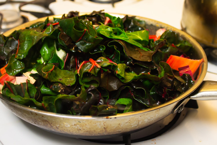 Chard being added to frying pan