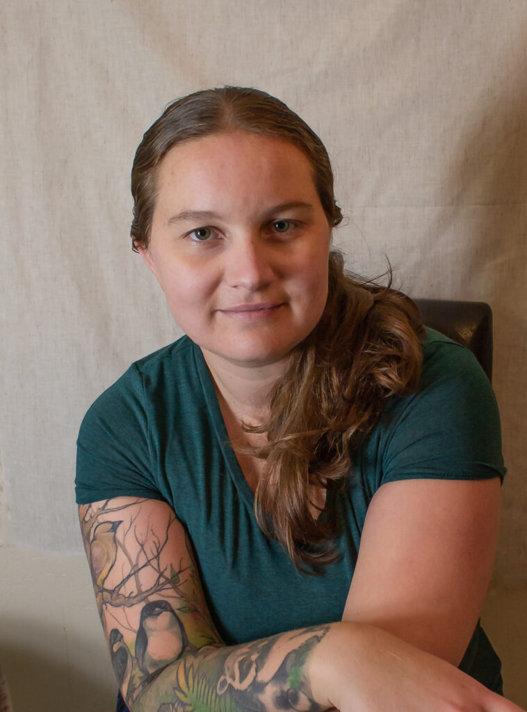 Woman sitting in a green shirt.