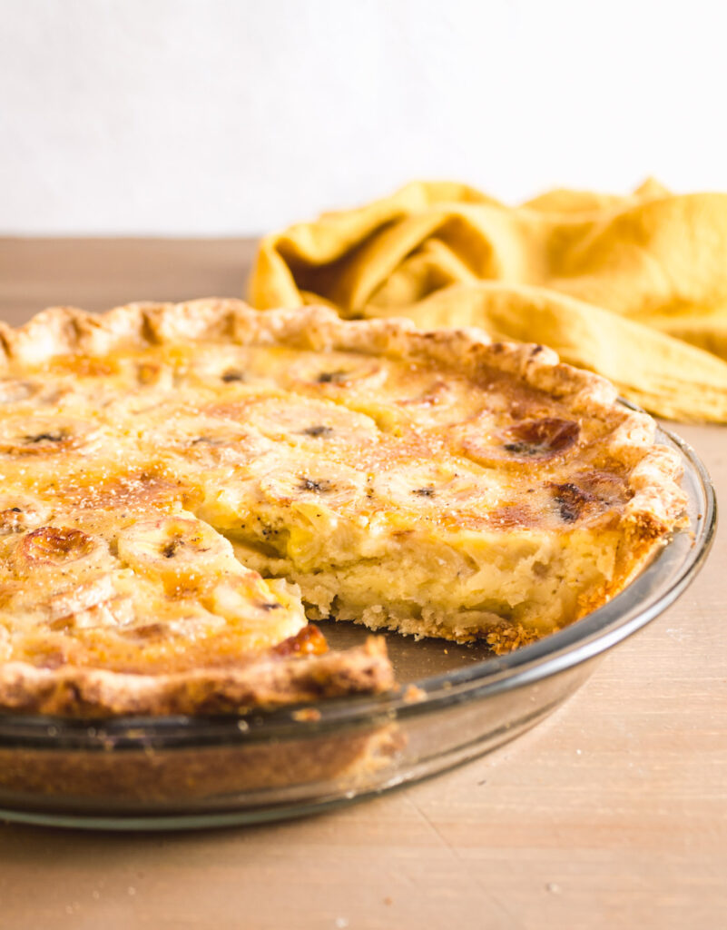 Banana pie with slice take out on a wood table