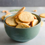 Teal bowl of gorgonzola walnut cookies on a blue background
